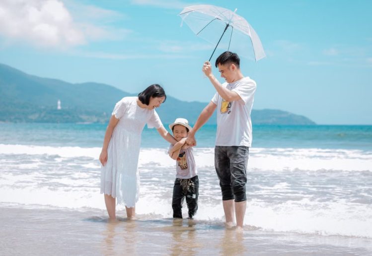 A joyful family enjoying a sunny day at Da Nang Beach, Vietnam, showcasing a heartwarming moment.