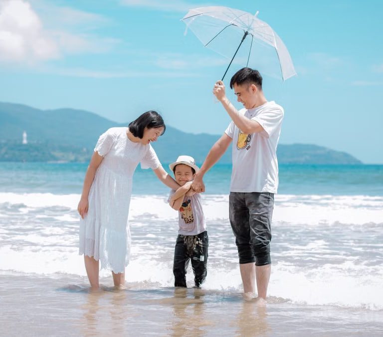 A joyful family enjoying a sunny day at Da Nang Beach, Vietnam, showcasing a heartwarming moment.
